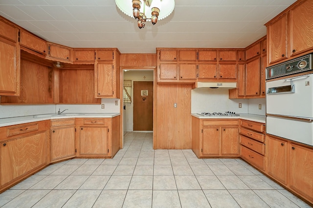 702 Mcdaniel St, Houston, TX 77022 - kitchen featuring white oven, light countertops, a warming drawer, gas cooktop, and under cabinet range hood