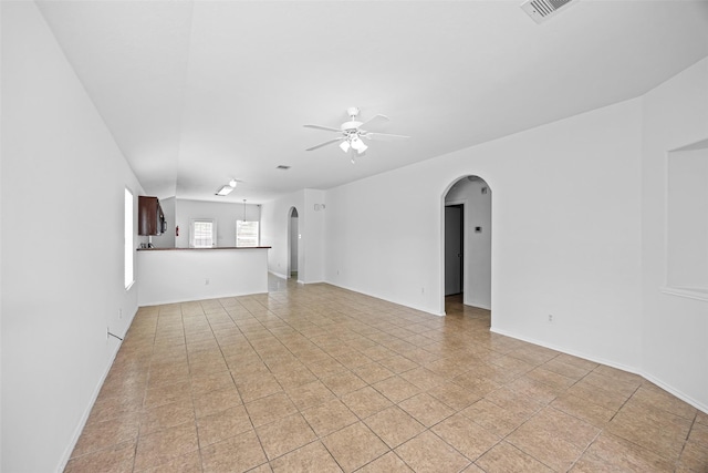 2850 Back Bay Brook Trl, Houston, TX 77045 - unfurnished living room with arched walkways, a ceiling fan, and light tile patterned flooring