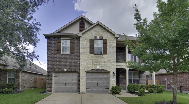 17410 Sandalisle Ln, Richmond, TX 77407 - view of front of home with stone siding, driveway, a garage, brick siding, and a balcony