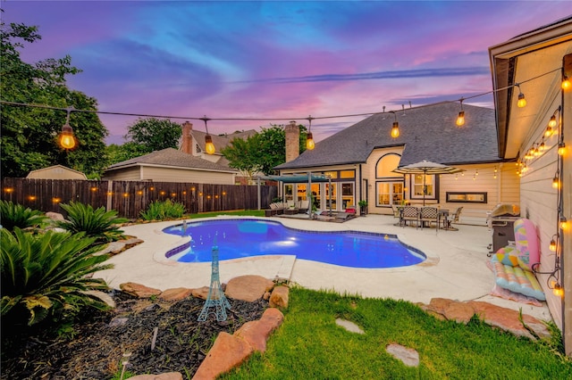 5631 Spring Lodge Dr, Houston, TX 77345 - pool at dusk featuring a patio area, a fenced backyard, and a grill
