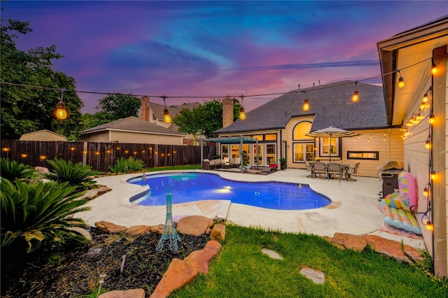 5631 Spring Lodge Dr, Houston, TX 77345 - pool at dusk featuring a patio, a fenced backyard, and area for grilling