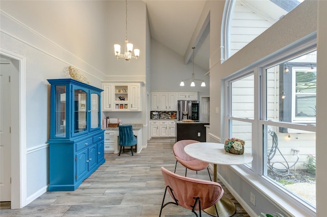 5631 Spring Lodge Dr, Houston, TX 77345 - dining room with high vaulted ceiling, a chandelier, and light wood finished floors