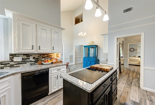 5631 Spring Lodge Dr, Houston, TX 77345 - kitchen featuring black appliances, a towering ceiling, white cabinets, decorative backsplash, and light wood-style flooring