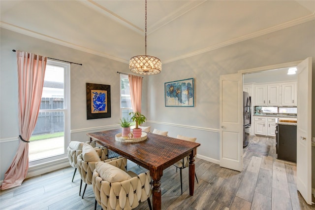 5631 Spring Lodge Dr, Houston, TX 77345 - dining area featuring light wood-style flooring, a chandelier, crown molding, and a raised ceiling