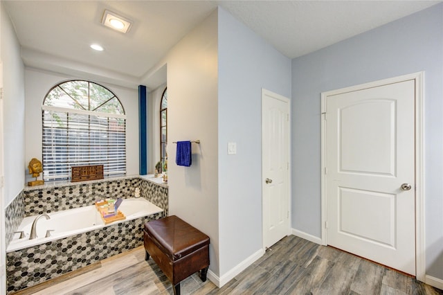 5631 Spring Lodge Dr, Houston, TX 77345 - bathroom featuring a garden tub and wood finished floors