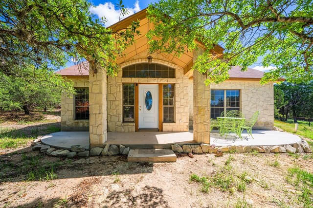 172 Candy Rd, Pipe Creek, TX 78063 - doorway to property with stone siding and covered porch