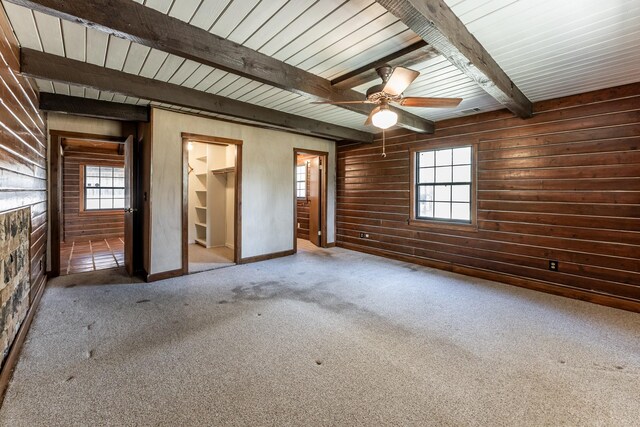 800 Fm 980 S, Point Blank, TX 77364 - unfurnished room with wooden walls, carpet, plenty of natural light, a ceiling fan, and a wood ceiling with exposed beams