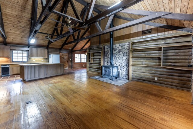 800 Fm 980 S, Point Blank, TX 77364 - unfurnished living room with a wood stove, light wood-type flooring, healthy amount of natural light, a wood ceiling with exposed beams, and log walls