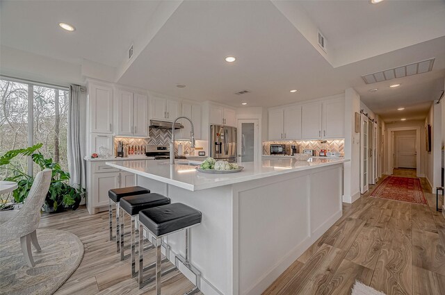 6628 Bayou Glen Rd Unit 6628, Houston, TX 77057 - kitchen featuring appliances with stainless steel finishes, light countertops, tasteful backsplash, white cabinetry, and recessed lighting