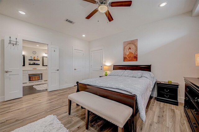 6628 Bayou Glen Rd Unit 6628, Houston, TX 77057 - bedroom featuring light wood-style flooring, recessed lighting, ensuite bathroom, a fireplace, and ceiling fan