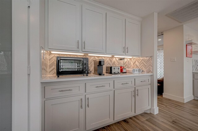 6628 Bayou Glen Rd Unit 6628, Houston, TX 77057 - kitchen featuring light countertops, white cabinetry, decorative backsplash, and light wood-type flooring