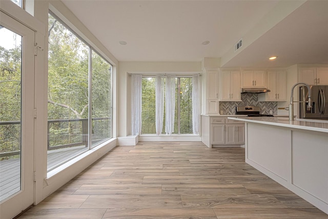 6628 Bayou Glen Rd Unit 6628, Houston, TX 77057 - kitchen featuring under cabinet range hood, appliances with stainless steel finishes, backsplash, light countertops, and recessed lighting