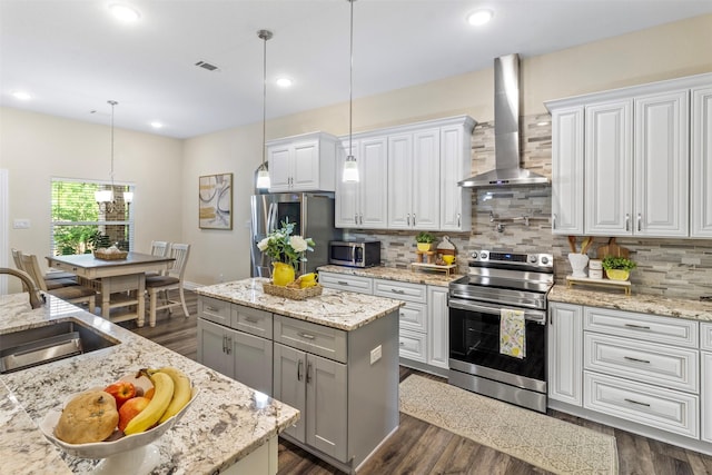13336 Lake Breeze Ln, Willis, TX 77318 - kitchen featuring appliances with stainless steel finishes, wall chimney range hood, a center island, decorative backsplash, and gray cabinetry