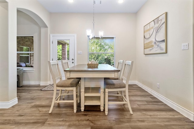 13336 Lake Breeze Ln, Willis, TX 77318 - dining room with wood finished floors, a chandelier, and arched walkways