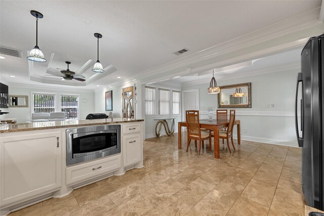 5227 Falvey St, Houston, TX 77017 - kitchen featuring stainless steel microwave, freestanding refrigerator, a ceiling fan, crown molding, and white cabinets