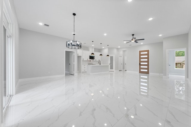 327 Paradise Ln, Montgomery, TX 77356 - unfurnished living room with light marble finish floors, recessed lighting, a chandelier, and a ceiling fan