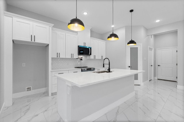 327 Paradise Ln, Montgomery, TX 77356 - kitchen with appliances with stainless steel finishes, recessed lighting, light marble finish floors, white cabinets, and a kitchen island with sink
