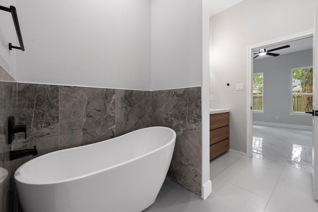 327 Paradise Ln, Montgomery, TX 77356 - full bath with tile walls, a freestanding tub, vanity, a wainscoted wall, and ceiling fan