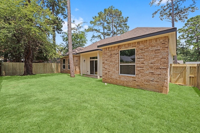 327 Paradise Ln, Montgomery, TX 77356 - rear view of house with a fenced backyard, a shingled roof, and brick siding
