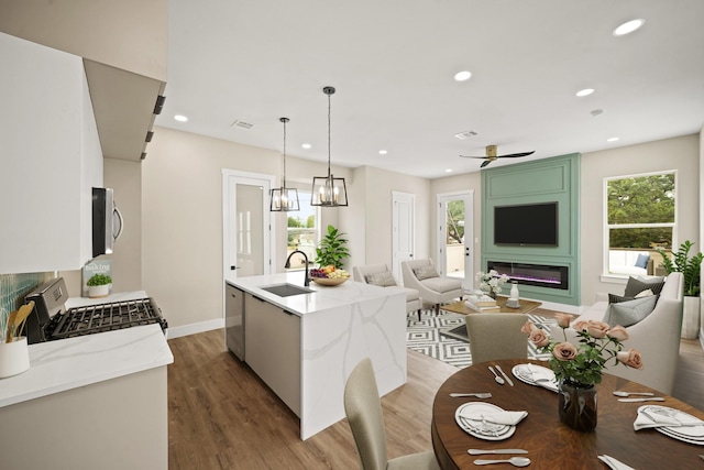 357 Cavalcade St, Houston, TX 77009 - kitchen featuring stainless steel appliances, open floor plan, light wood-type flooring, recessed lighting, and a center island with sink