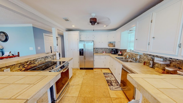 110 Four Master Rd, Freeport, TX 77541 - kitchen featuring appliances with stainless steel finishes, tile countertops, backsplash, white cabinets, and recessed lighting