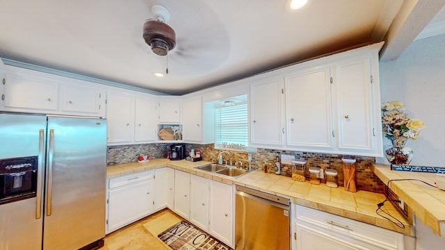 110 Four Master Rd, Freeport, TX 77541 - kitchen featuring stainless steel appliances, white cabinetry, tile counters, tasteful backsplash, and ceiling fan