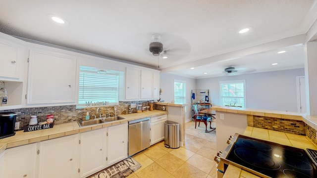 110 Four Master Rd, Freeport, TX 77541 - kitchen with appliances with stainless steel finishes, a ceiling fan, tile countertops, white cabinets, and backsplash