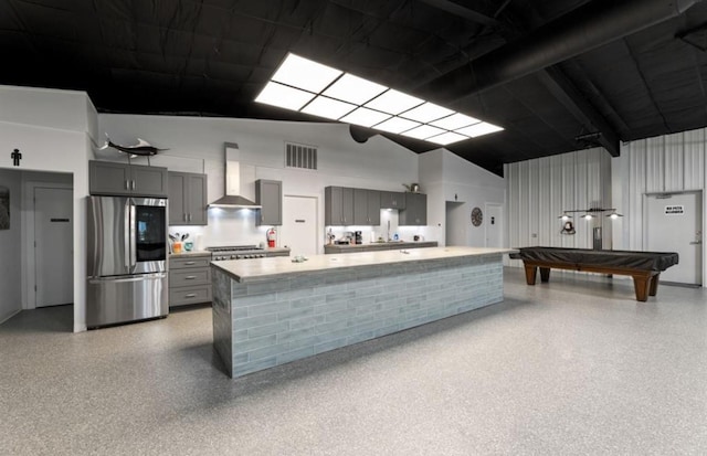 110 Four Master Rd, Freeport, TX 77541 - kitchen with stainless steel appliances, wall chimney exhaust hood, gray cabinets, a towering ceiling, and light countertops