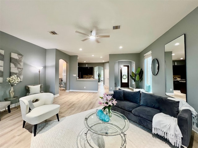 18718 Fairmont Springs Ct, Cypress, TX 77429 - living area featuring arched walkways, light wood finished floors, a ceiling fan, and recessed lighting