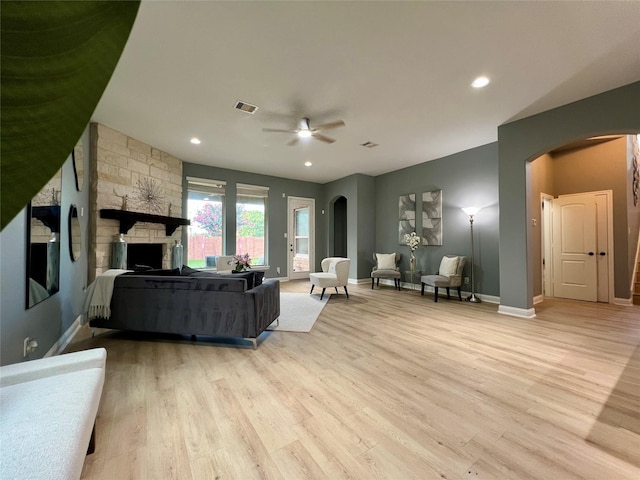 18718 Fairmont Springs Ct, Cypress, TX 77429 - living area with arched walkways, a ceiling fan, light wood-type flooring, a fireplace, and recessed lighting