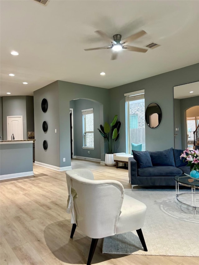 18718 Fairmont Springs Ct, Cypress, TX 77429 - living area with arched walkways, light wood-type flooring, ceiling fan, plenty of natural light, and recessed lighting