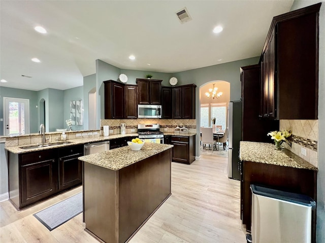 18718 Fairmont Springs Ct, Cypress, TX 77429 - kitchen featuring appliances with stainless steel finishes, a peninsula, backsplash, plenty of natural light, and recessed lighting