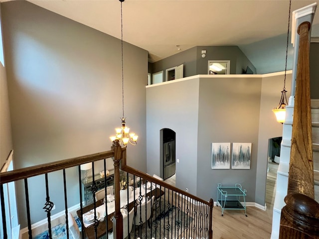18718 Fairmont Springs Ct, Cypress, TX 77429 - stairs with a chandelier, wood finished floors, high vaulted ceiling, and arched walkways