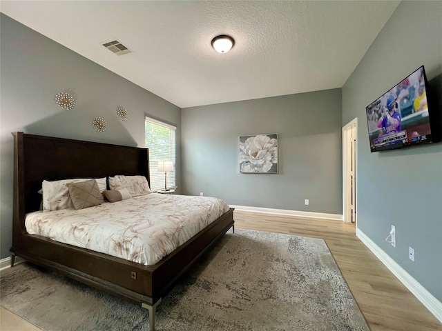 18718 Fairmont Springs Ct, Cypress, TX 77429 - bedroom with wood finished floors and a textured ceiling