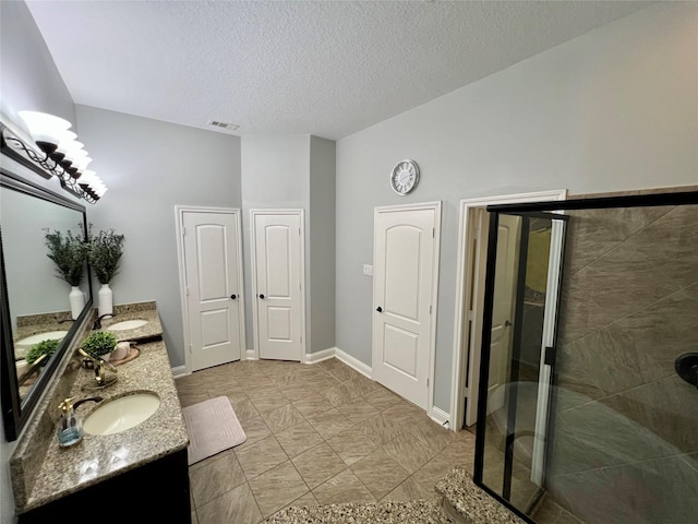 18718 Fairmont Springs Ct, Cypress, TX 77429 - bathroom featuring double vanity, a stall shower, and a textured ceiling