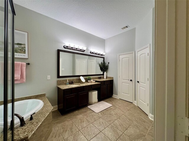 18718 Fairmont Springs Ct, Cypress, TX 77429 - bathroom featuring double vanity, a bath, a textured ceiling, and tile patterned flooring
