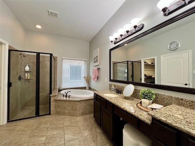 18718 Fairmont Springs Ct, Cypress, TX 77429 - bathroom featuring a garden tub, a stall shower, vanity, a spacious closet, and a textured ceiling