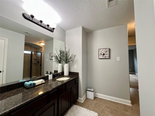 18718 Fairmont Springs Ct, Cypress, TX 77429 - bathroom featuring a shower stall, vanity, tile patterned floors, and a textured ceiling
