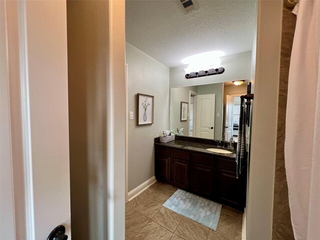 18718 Fairmont Springs Ct, Cypress, TX 77429 - full bathroom with double vanity, a textured ceiling, and tile patterned flooring