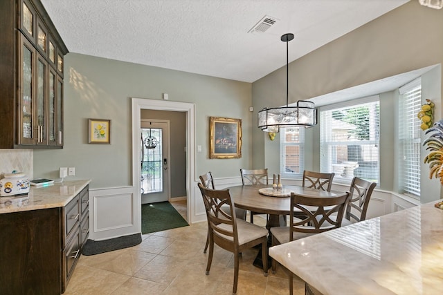 6430 Willow Pine Dr, Spring, TX 77379 - dining space featuring light tile patterned floors, a textured ceiling, and wainscoting