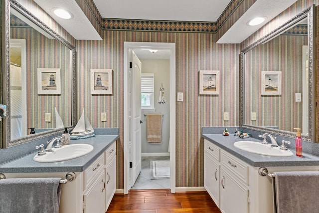 6430 Willow Pine Dr, Spring, TX 77379 - full bathroom with two vanities, wood finished floors, and wallpapered walls