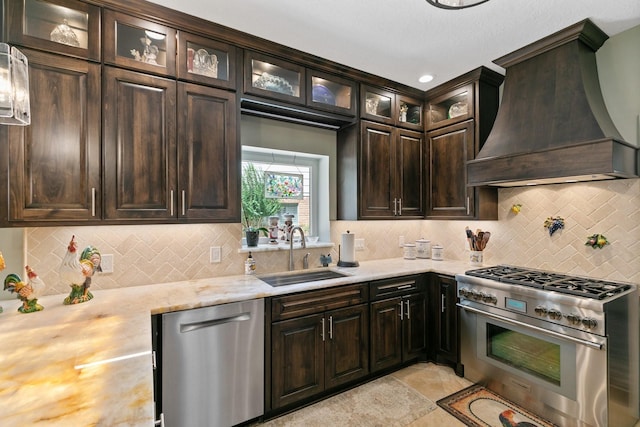 6430 Willow Pine Dr, Spring, TX 77379 - kitchen with stainless steel appliances, custom exhaust hood, decorative backsplash, dark brown cabinetry, and glass insert cabinets