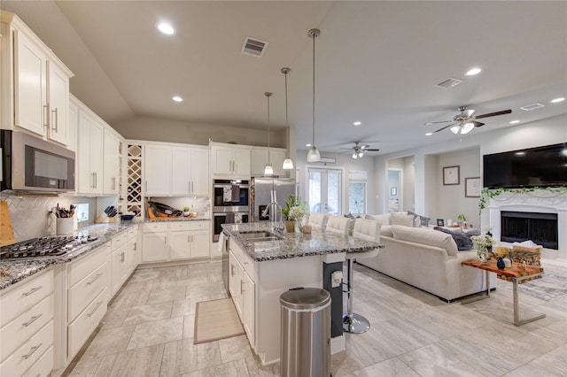 3502 Harper Ferry Pl, Katy, TX 77494 - kitchen with stainless steel appliances, open floor plan, decorative backsplash, recessed lighting, and light stone counters