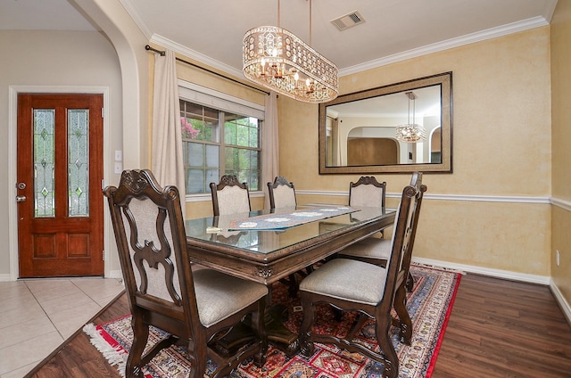 8711 Chamomile Meadow Trl, Katy, TX 77494 - dining room with wood finished floors, a chandelier, ornamental molding, and arched walkways