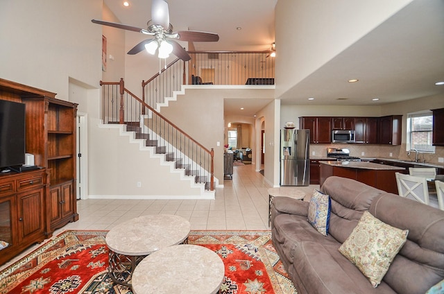 8711 Chamomile Meadow Trl, Katy, TX 77494 - living area with light tile patterned floors, a high ceiling, a ceiling fan, stairs, and recessed lighting