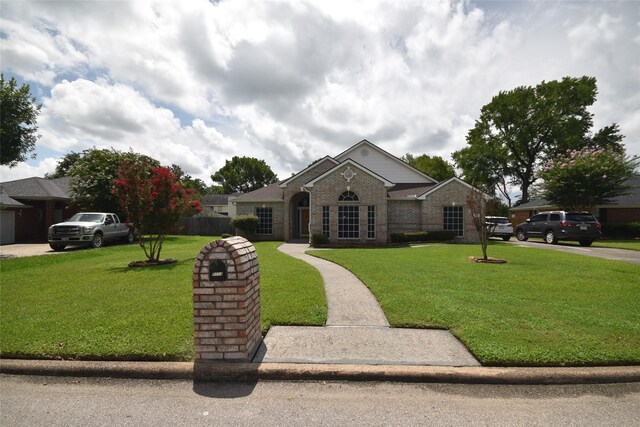 5113 Greenwater Dr, Willis, TX 77318 - view of front facade featuring a front yard and brick siding
