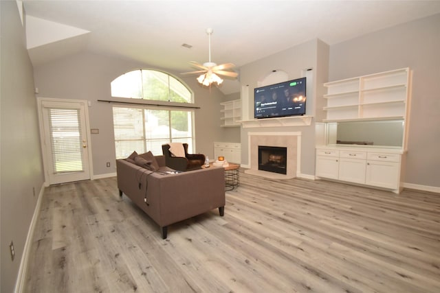5113 Greenwater Dr, Willis, TX 77318 - living room with a tile fireplace, light wood-type flooring, a ceiling fan, and high vaulted ceiling