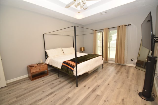 5113 Greenwater Dr, Willis, TX 77318 - bedroom with light wood finished floors and a tray ceiling