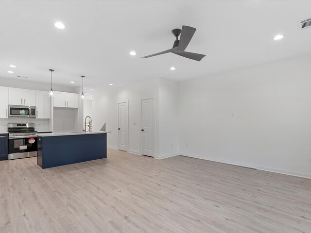 5702 Elysian St, Houston, TX 77009 - kitchen featuring stainless steel appliances, light wood-style flooring, ceiling fan, recessed lighting, and white cabinets