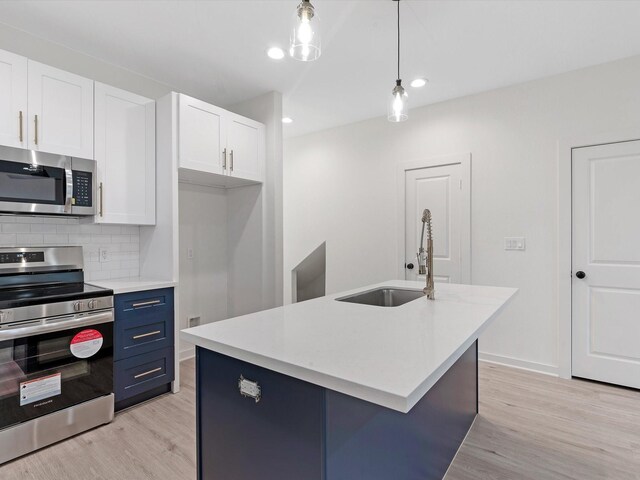 5702 Elysian St, Houston, TX 77009 - kitchen featuring appliances with stainless steel finishes, light wood finished floors, white cabinetry, decorative backsplash, and recessed lighting